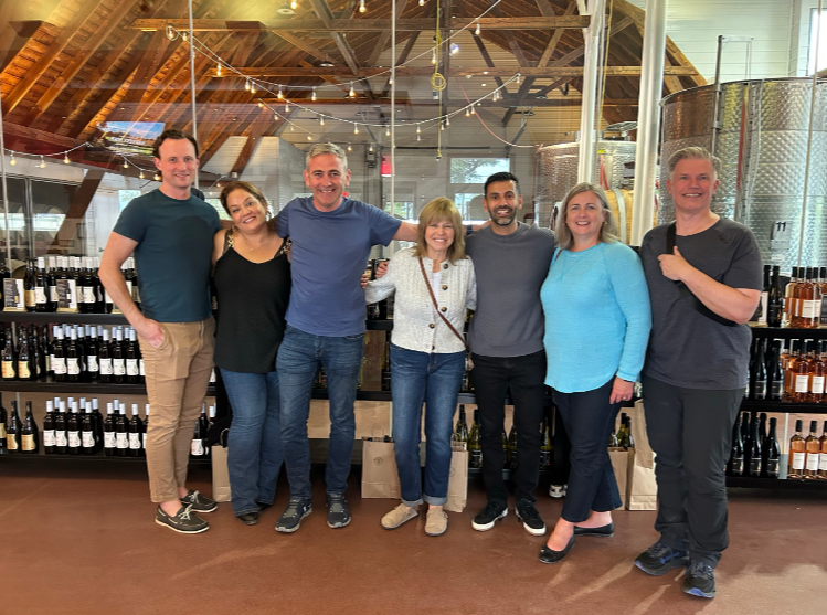 Basil Marcus stands with the leadership team of Foss National Leasing at a winery during the leadership offsite 2024. 