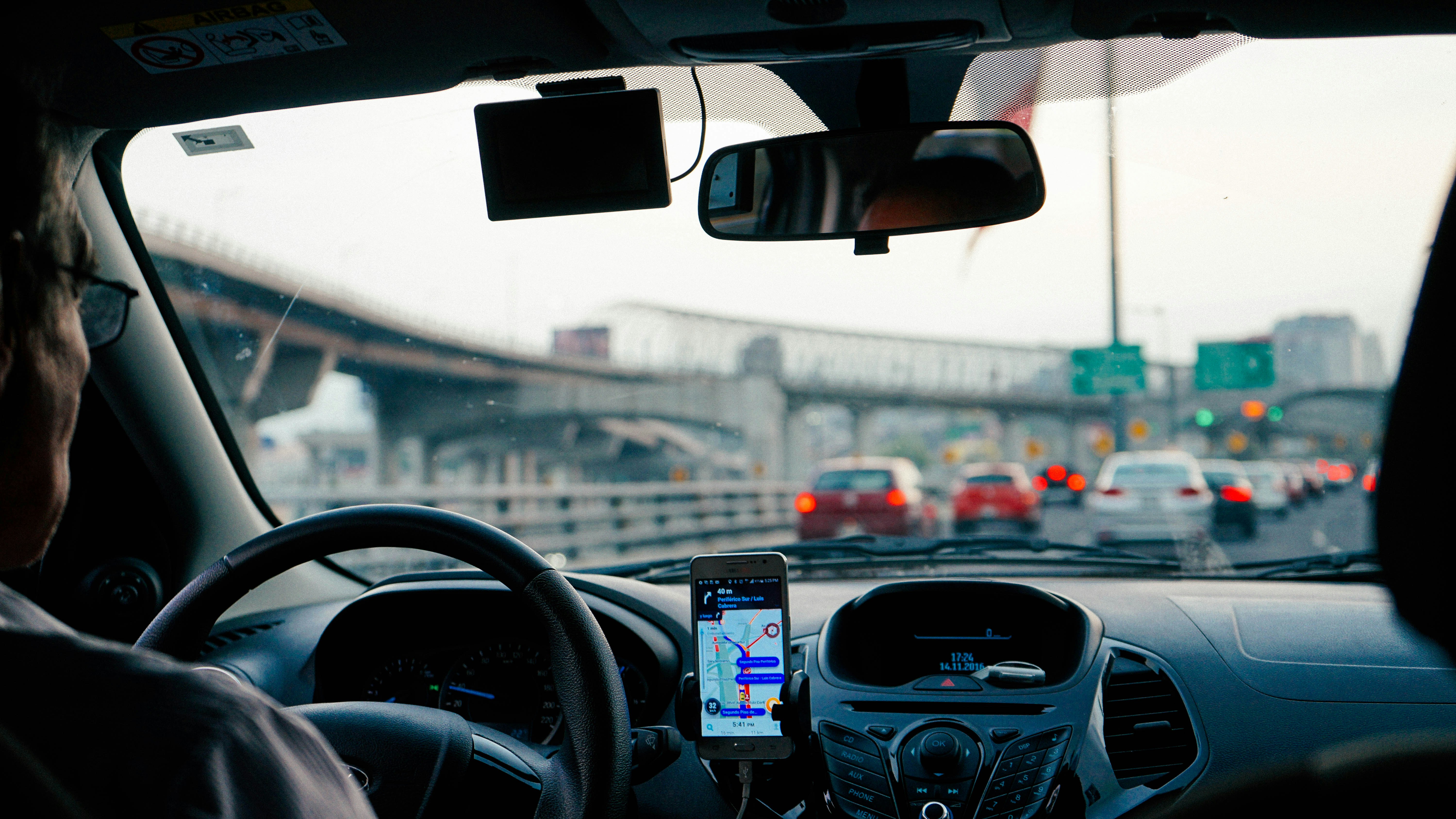 Fleet driver using GPS navigation app in heavy traffic — showing how route planning reduces idle time and fuel consumption